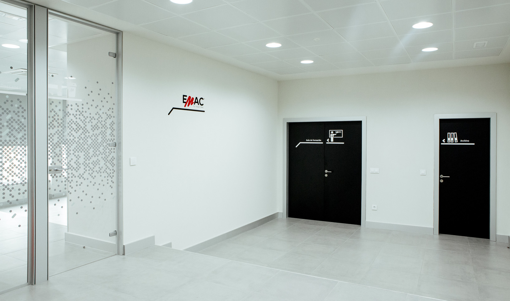 rotulacion oficinas emac_13 Proyecto de rotulación y señalética para las nuevas oficinas de EMAC Complementos. La propuesta gráfica parte del octógono como módulo base, símbolo distintivo y de calidad para EMAC, que utiliza troquelado en la mayoría de sus perfiles. Una trama aparentemente irregular de octógonos de vinilo blanco mate opaco y traslúcido gris se extiende como una nebulosa por los paramentos verticales de vidrio que cierran los despachos y salas de reuniones, consiguiendo cierta intimidad en el interior.